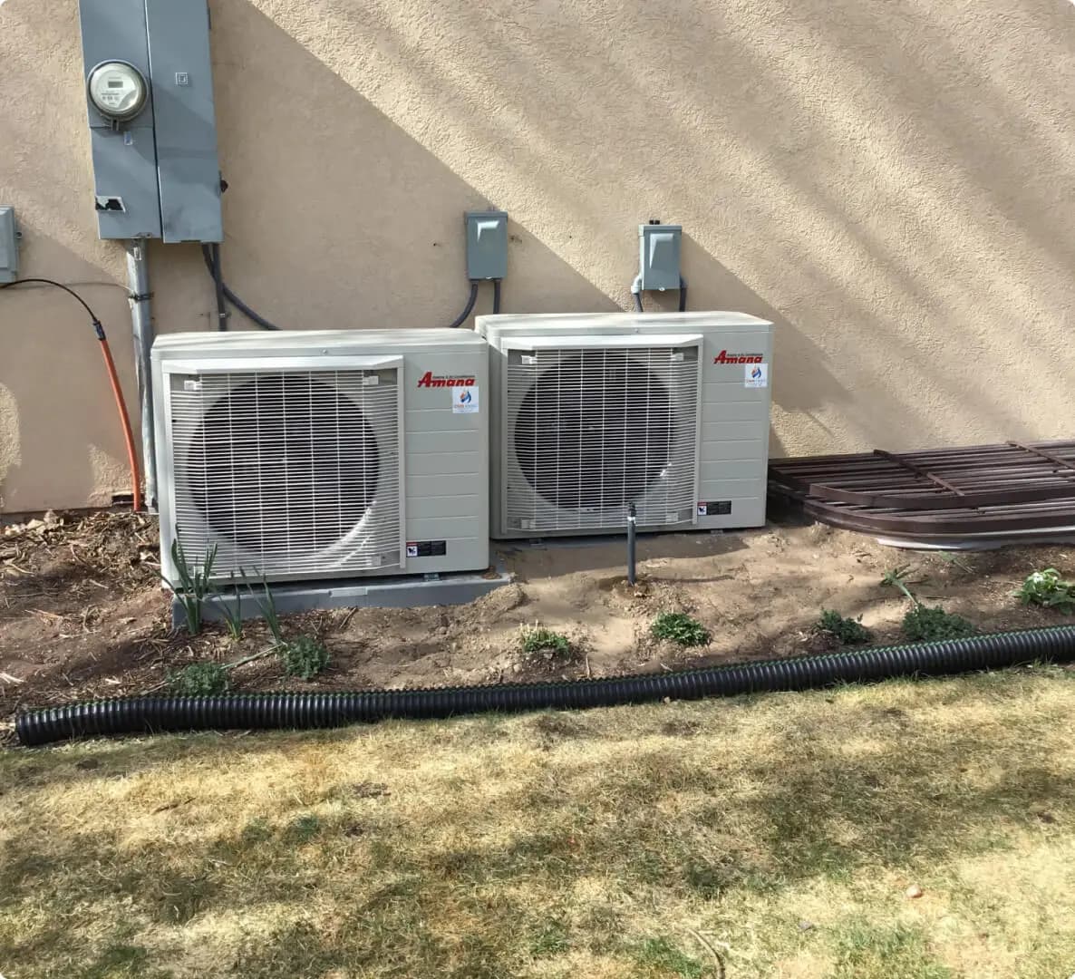 Amana air conditioner condenser beside a house in landscaping rock