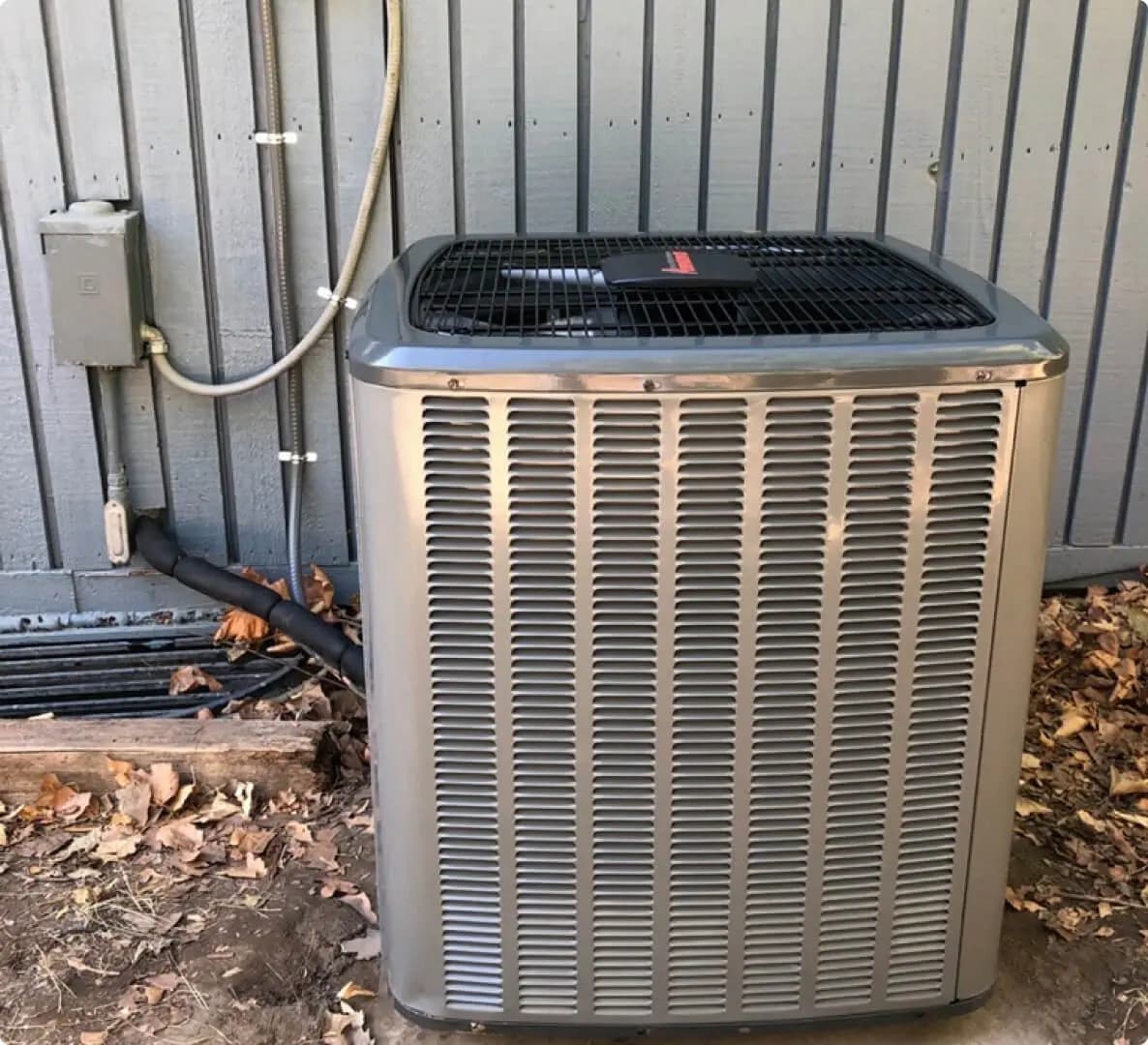 Outdoor central air conditioning unit beside a house