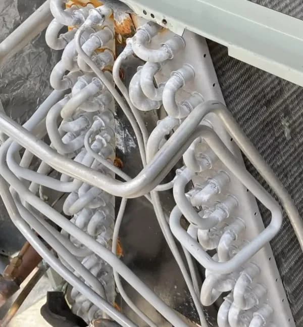 Technician cleaning a split-system evaporator coil