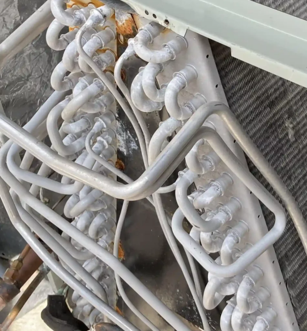 Technician cleaning a split-system evaporator coil