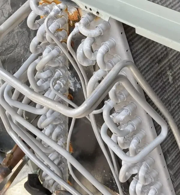 Technician cleaning a split-system evaporator coil